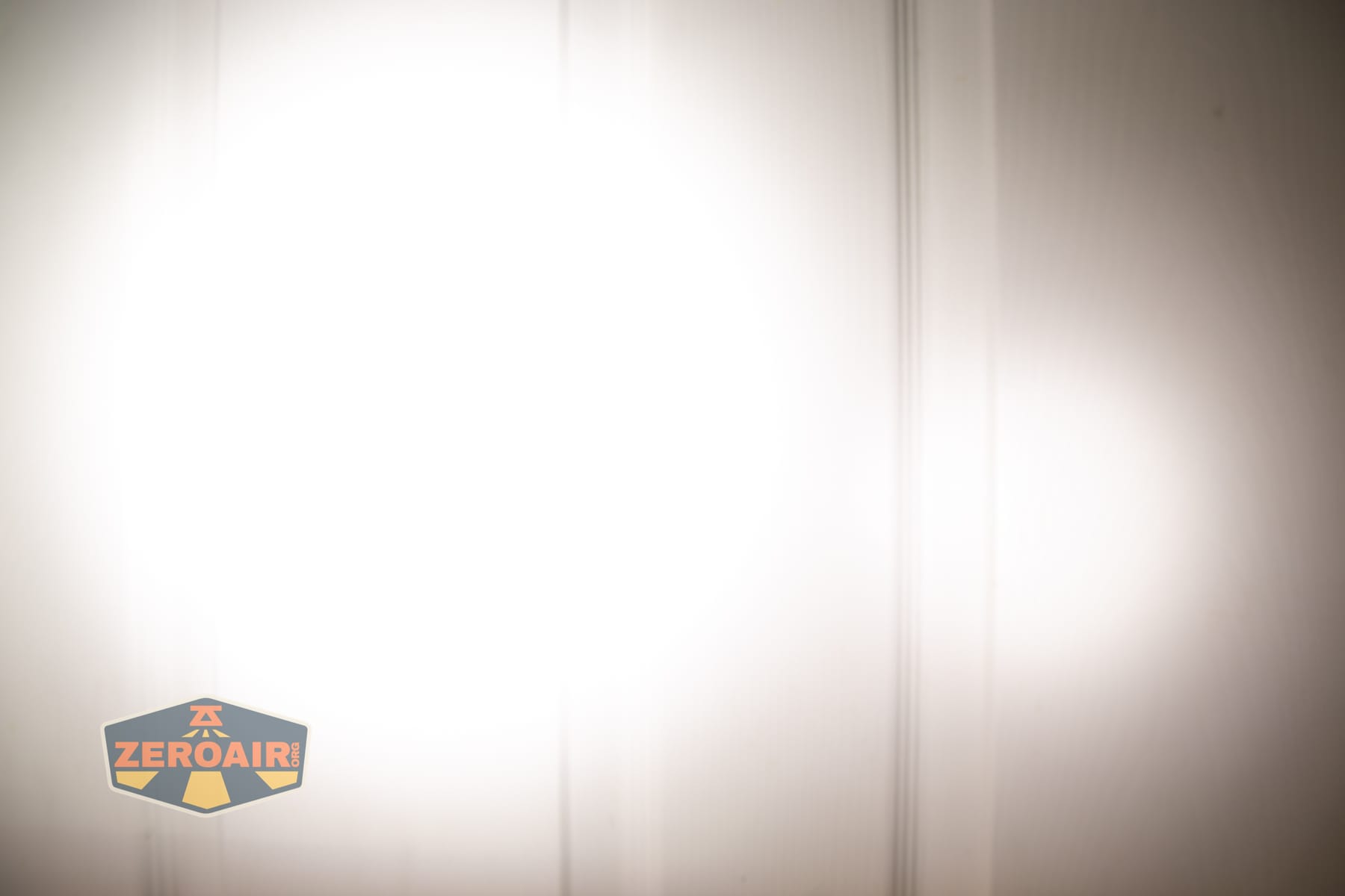 Reylight Dawn Max titanium flashlight beamshots on door (at 1') compared to nichia 219b 4500K