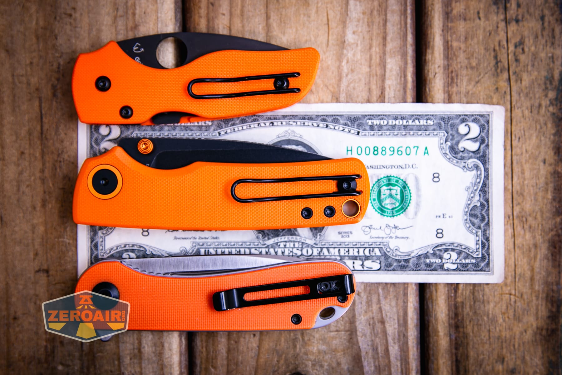 Vosteed Porcupine G10 Orange knife on a two dollar bill compared to Civivi Elementum in orange