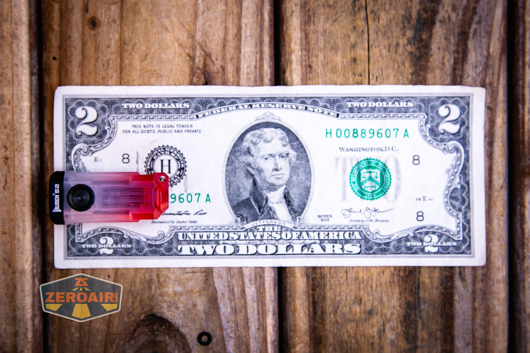 Wuben E2 Pulse keychain flashlight on a two dollar bill