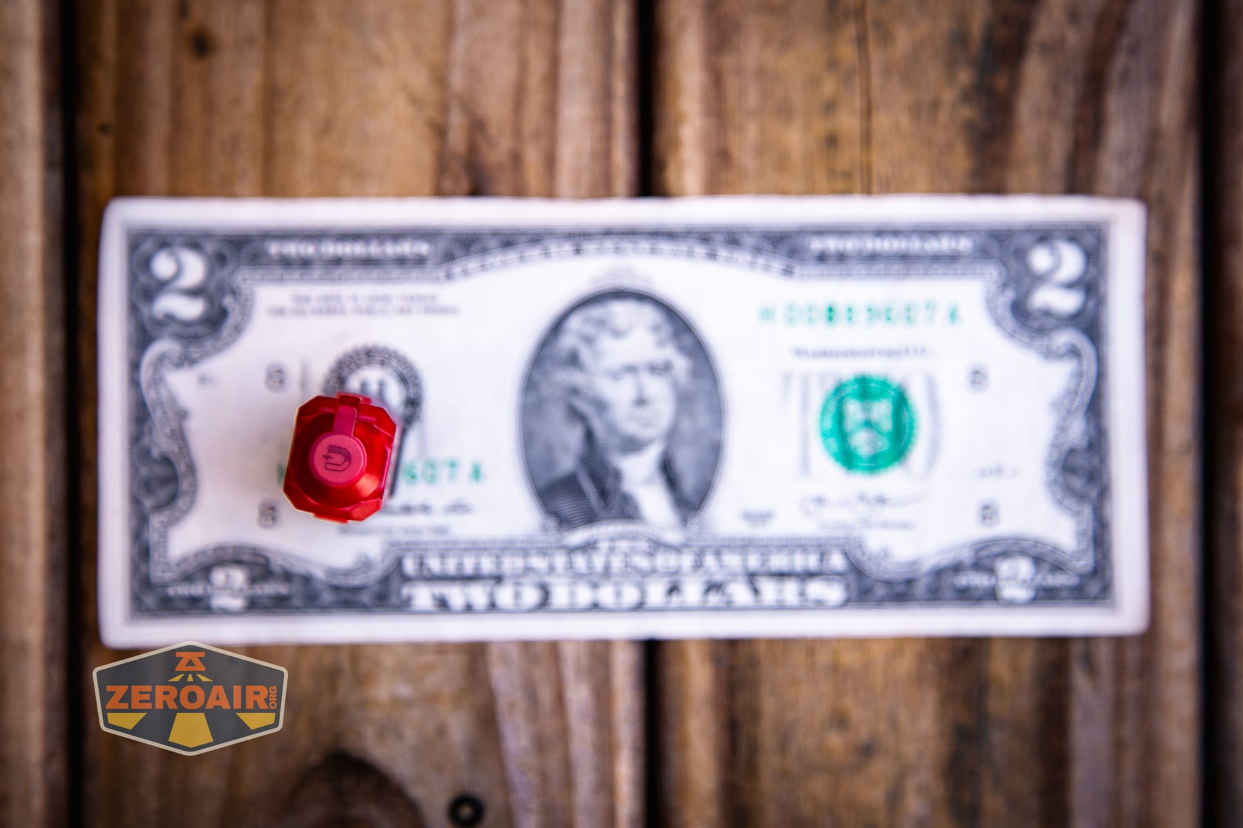 Wuben E2 Pulse keychain flashlight on a two dollar bill