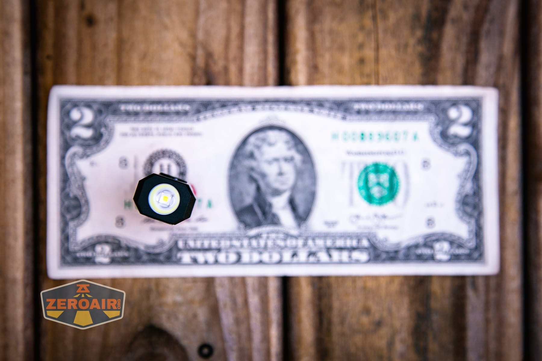 Wuben E2 Pulse keychain flashlight on a two dollar bill