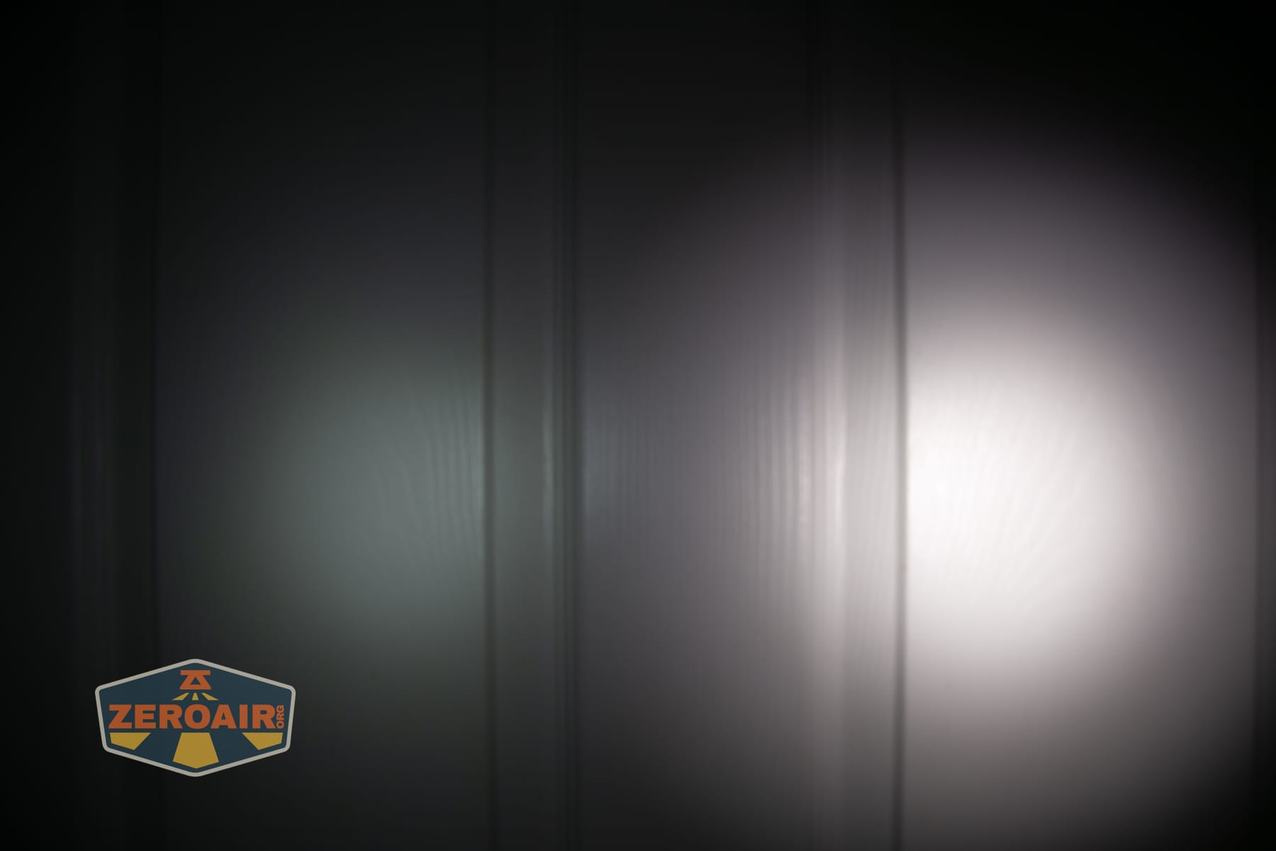 Wuben E2 Pulse keychain flashlight beamshots on door (at 1') compared to nichia 219b 4500K