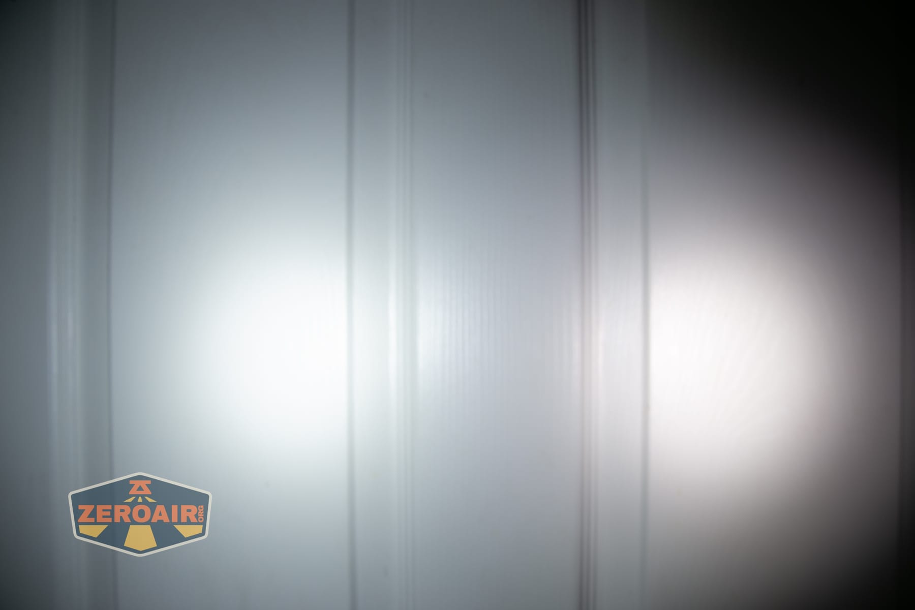 Wuben E2 Pulse keychain flashlight beamshots on door (at 1') compared to nichia 219b 4500K