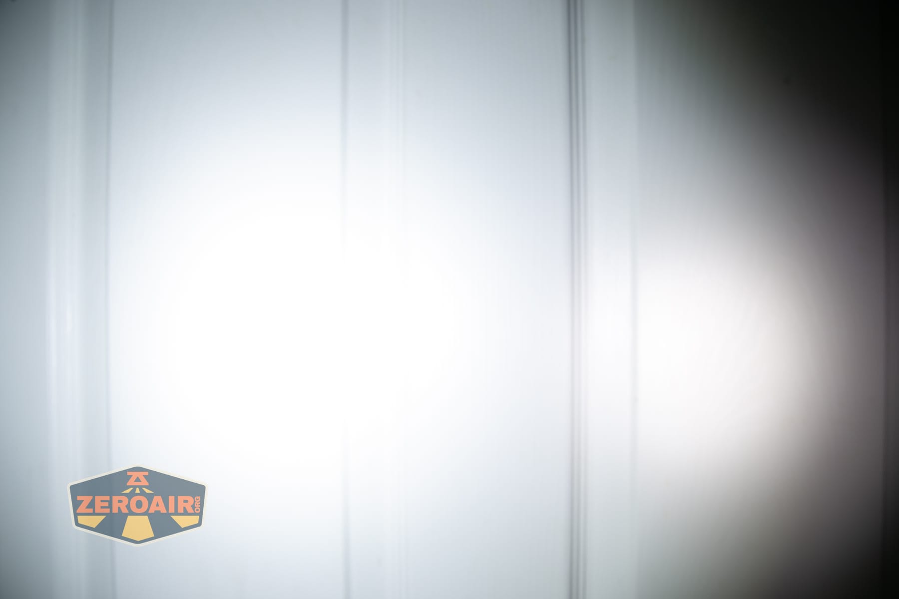 Wuben E2 Pulse keychain flashlight beamshots on door (at 1') compared to nichia 219b 4500K