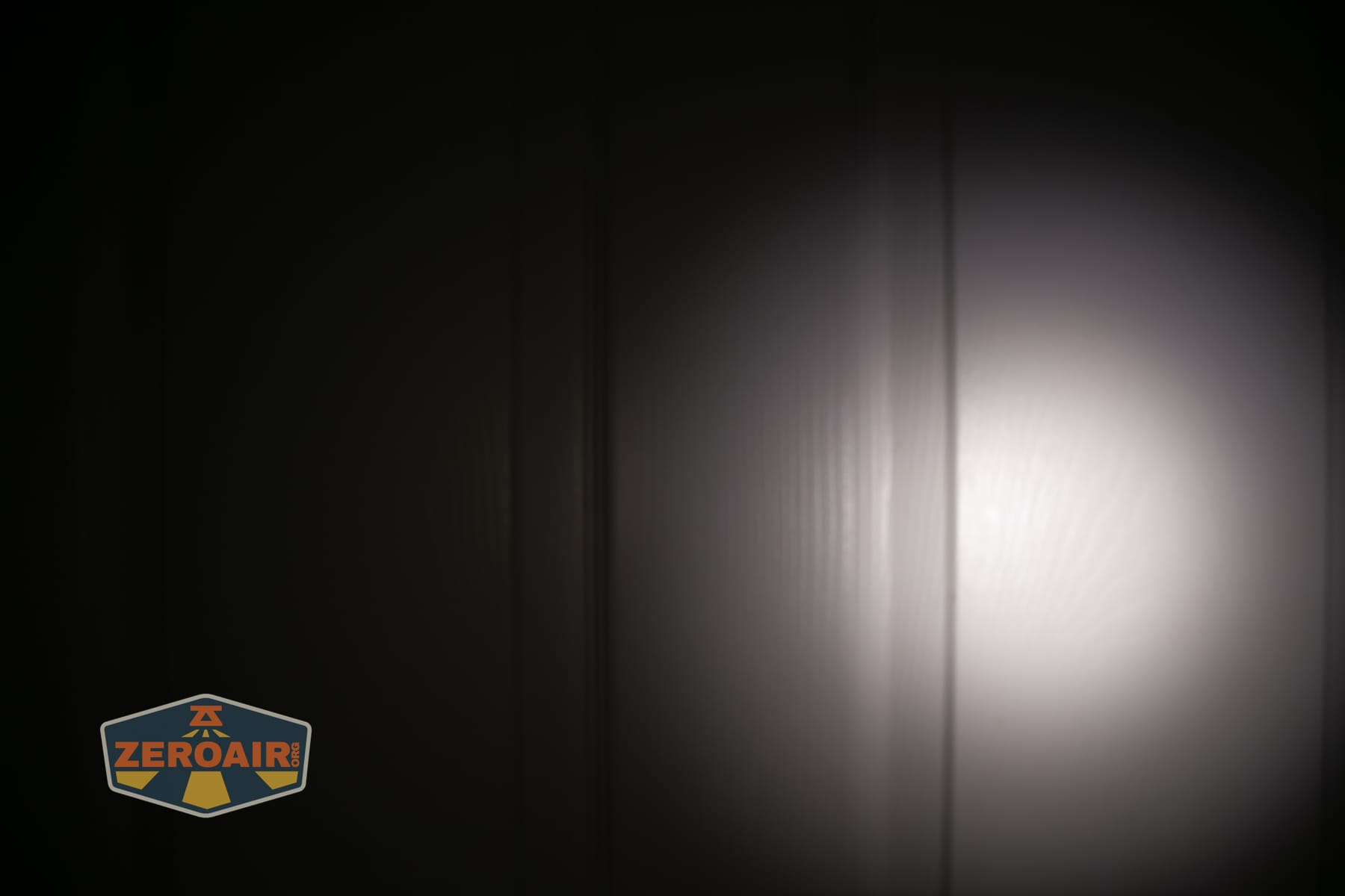 Wuben E2 Pulse keychain flashlight beamshots on door (at 1') compared to nichia 219b 4500K