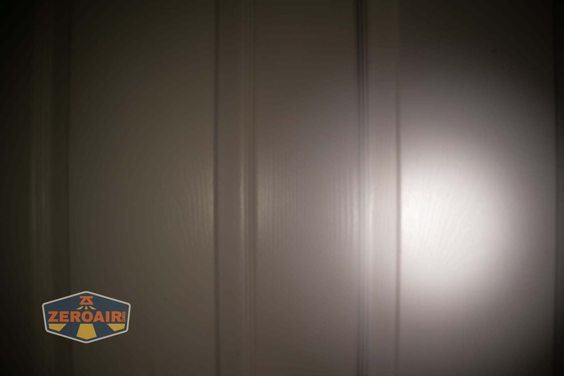 Wuben E2 Pulse keychain flashlight beamshots on door (at 1') compared to nichia 219b 4500K