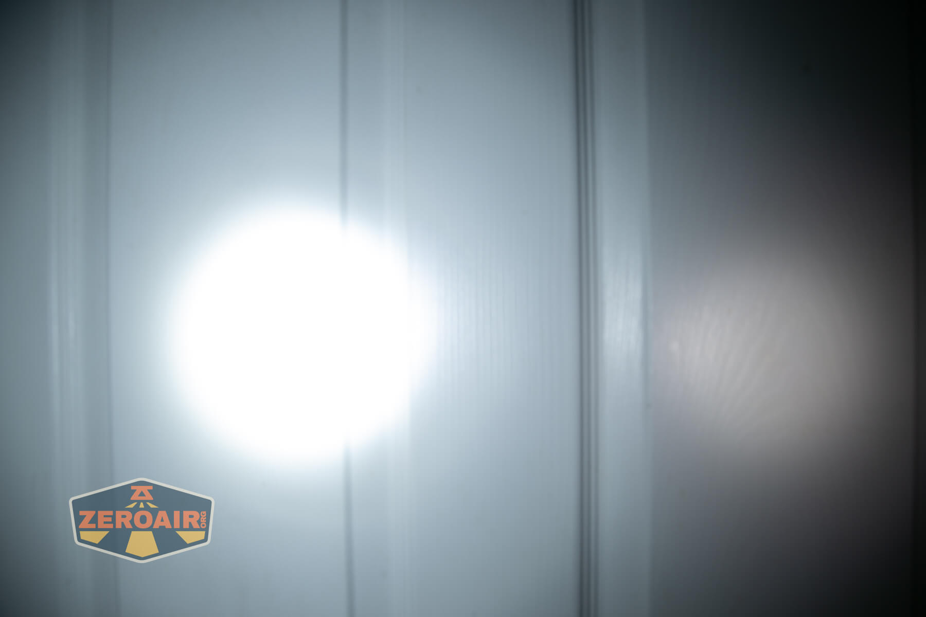 Olight Oknife MK beamshots on door (at 1') compared to nichia 219b 4500K