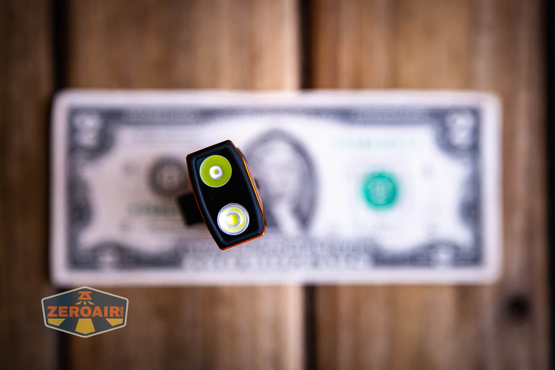 Olight ArkPro Ultra Orange flat EDC flashlight on a two dollar bill