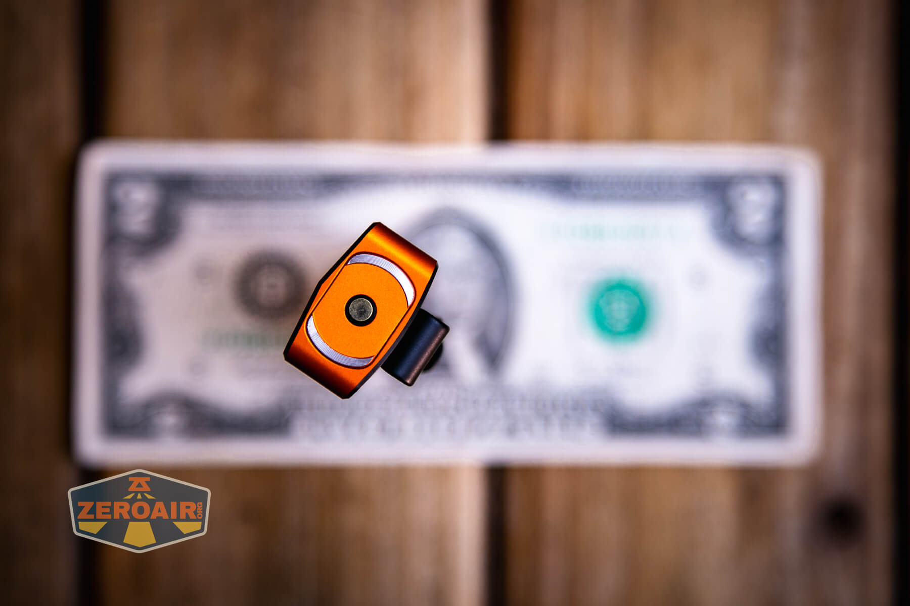 Olight ArkPro Ultra Orange flat EDC flashlight on a two dollar bill