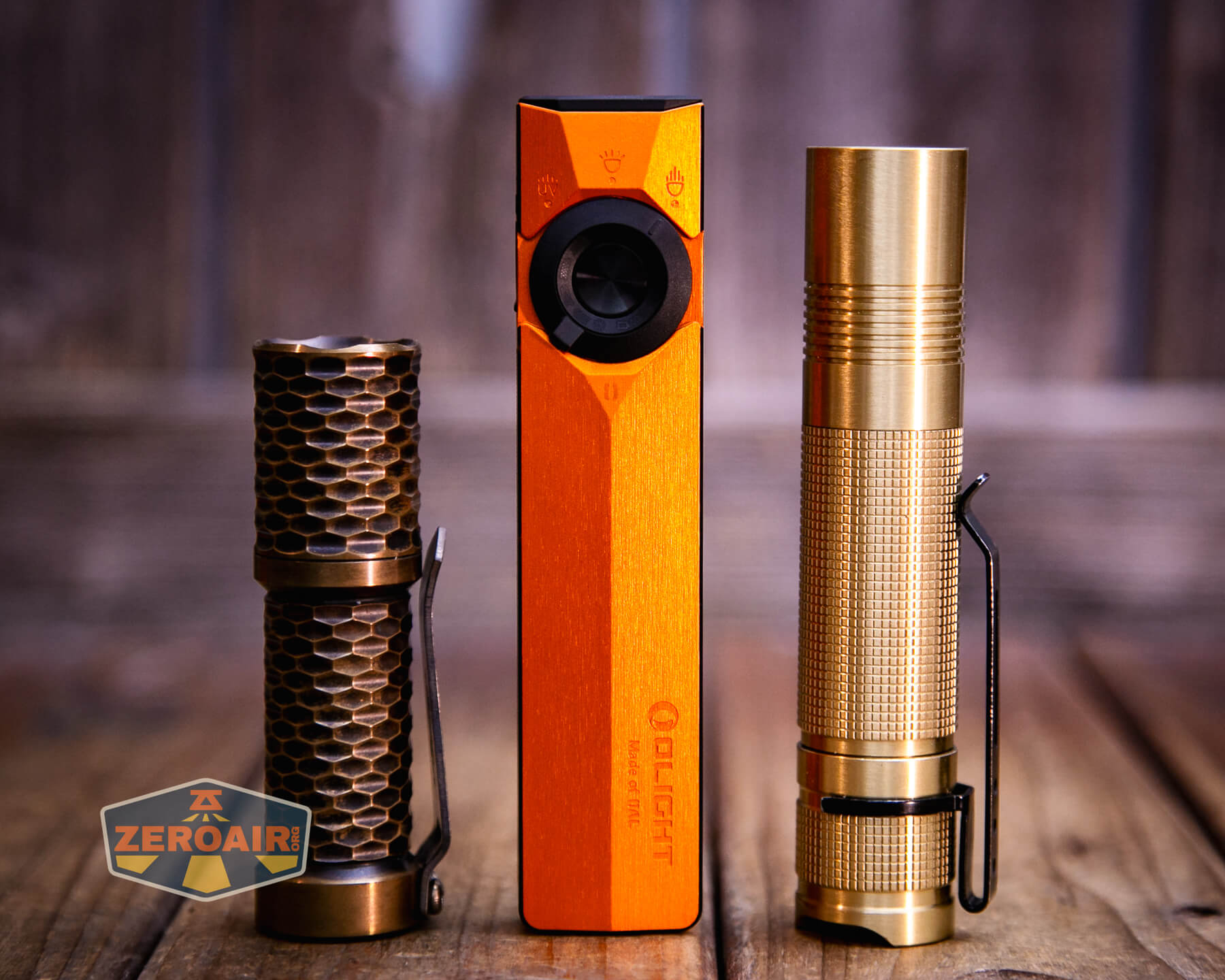 Olight ArkPro Ultra Orange flat EDC flashlight with two standard sized flashlights