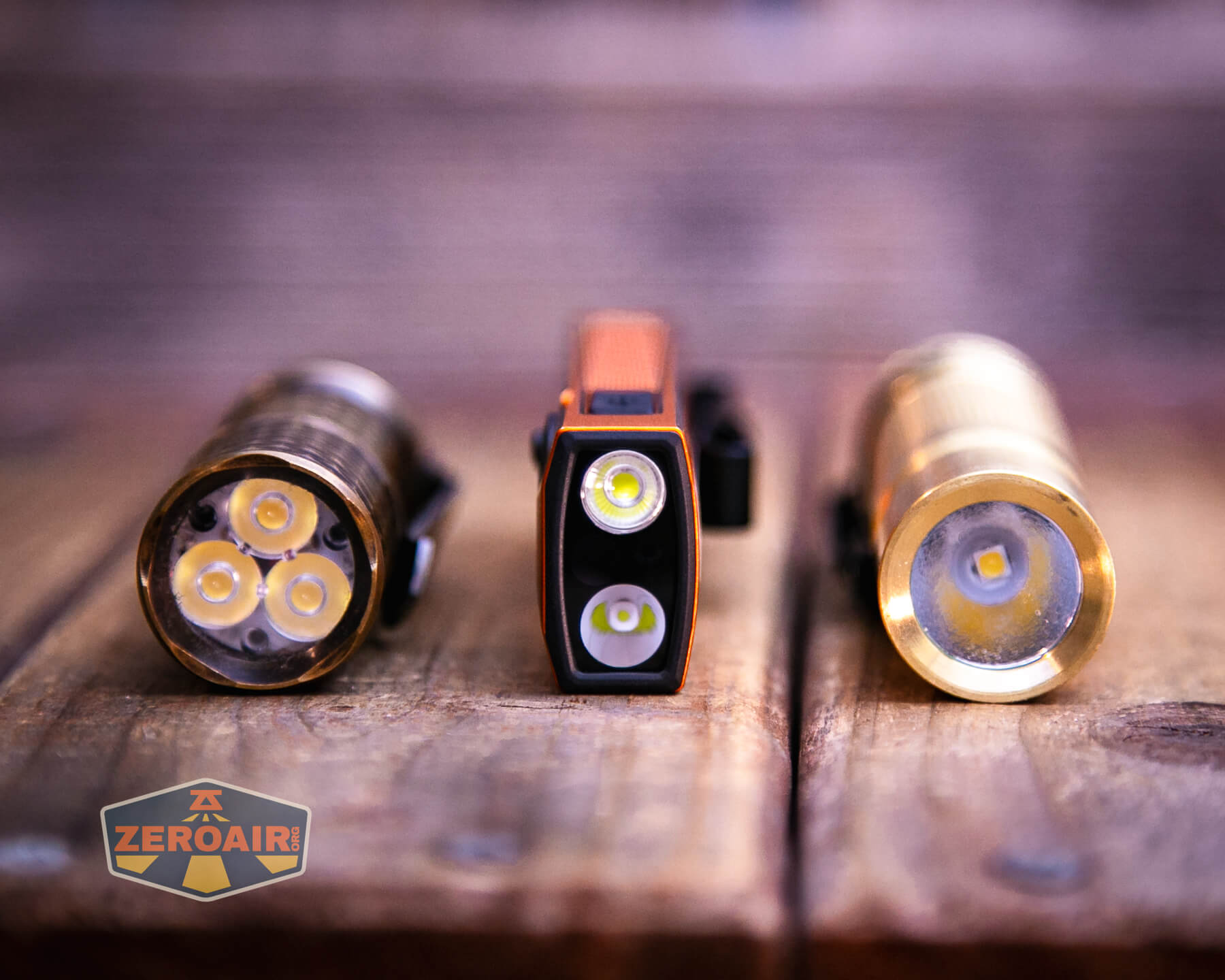 Olight ArkPro Ultra Orange flat EDC flashlight with two standard sized flashlights