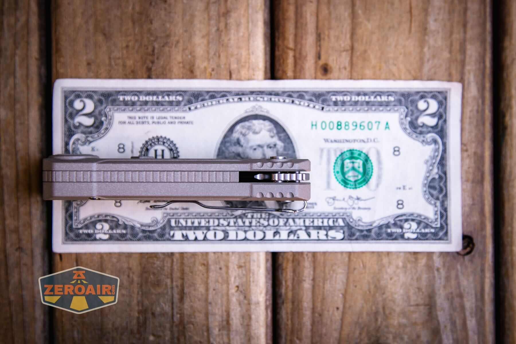 Olight Oknife LK folding knife flashlight on a two dollar bill