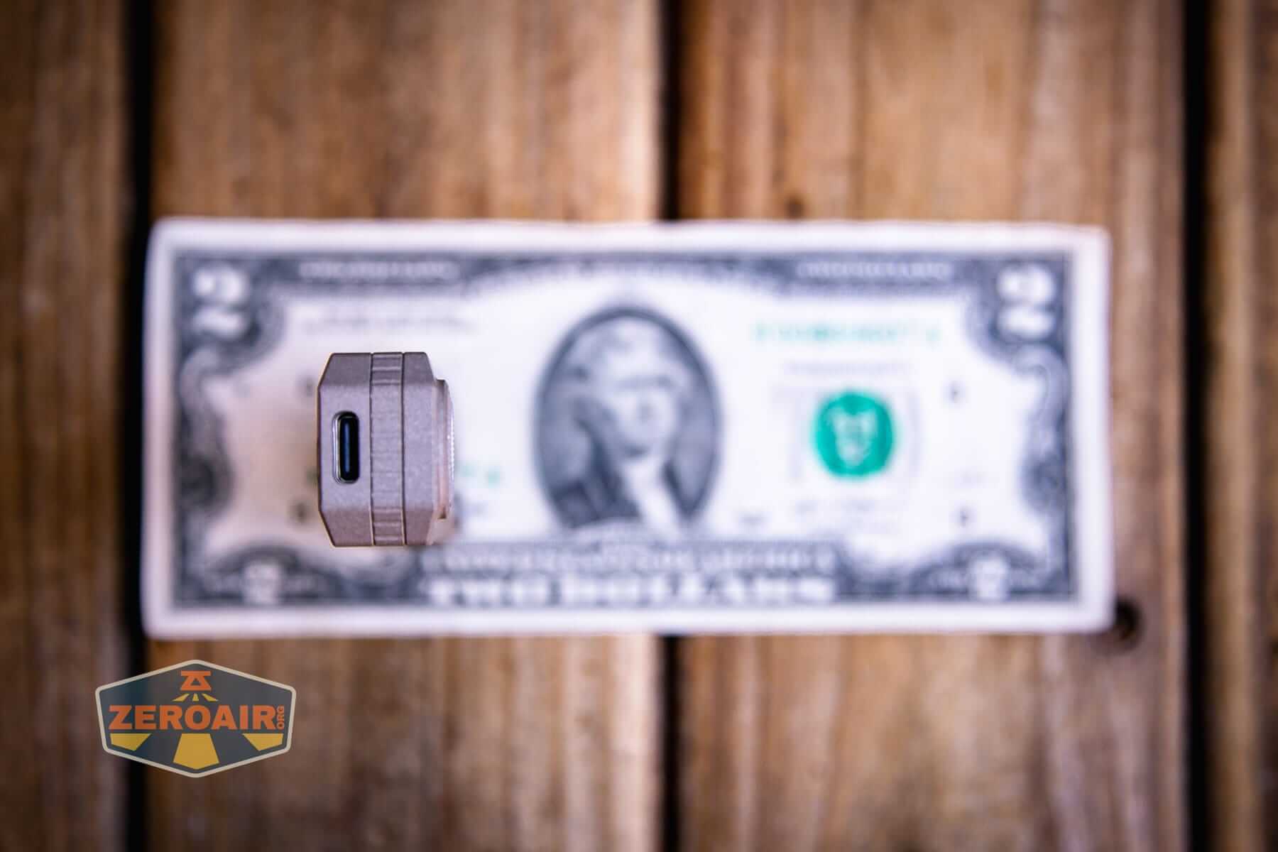 Olight Oknife LK folding knife flashlight on a two dollar bill
