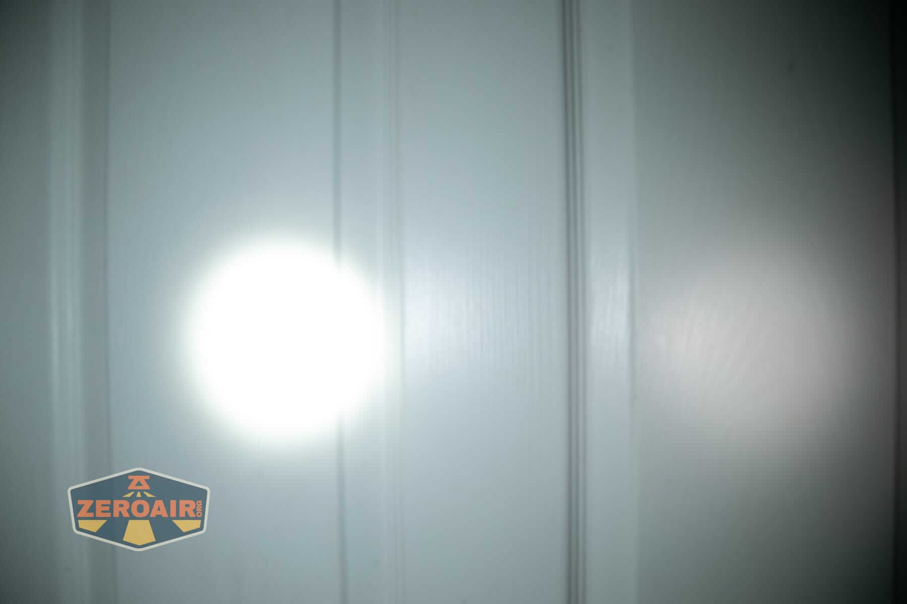 Olight Oknife LK folding knife flashlight beamshots on door (at 1') compared to nichia 219b 4500K