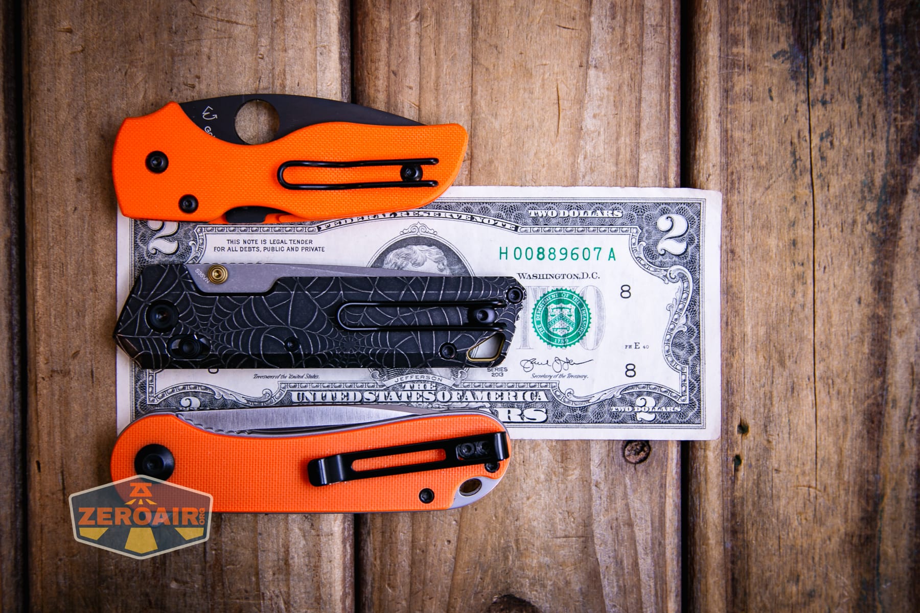Vosteed Parallel Spiderweb knife on a two dollar bill compared to Civivi Elementum in orange