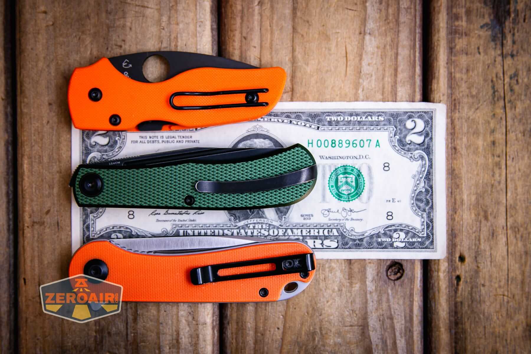 Daedalus Green Lab knife on a two dollar bill compared to Civivi Elementum in orange