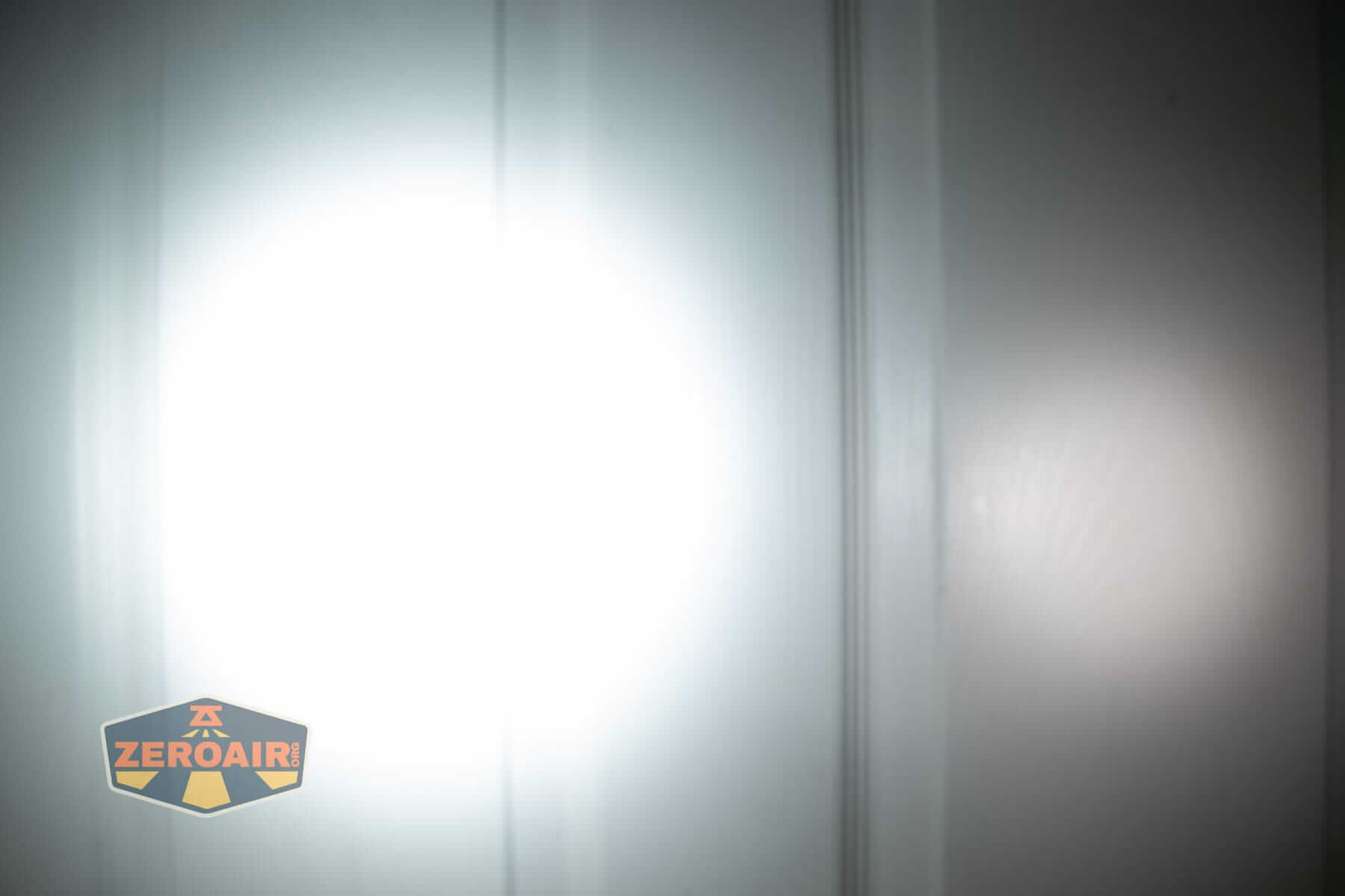 Speras M4 V3 compact EDC flashlight beamshots on door (at 1') compared to nichia 219b 4500K