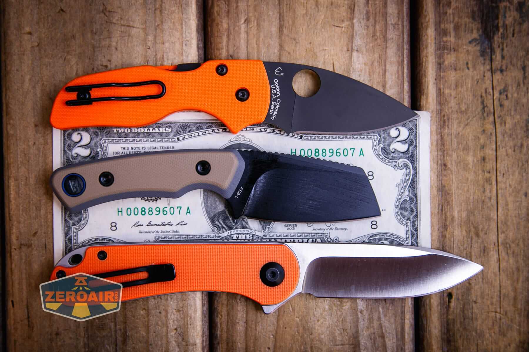Vosteed Marmoset Sand fixed blade knife on a two dollar bill compared to Civivi Elementum in orange