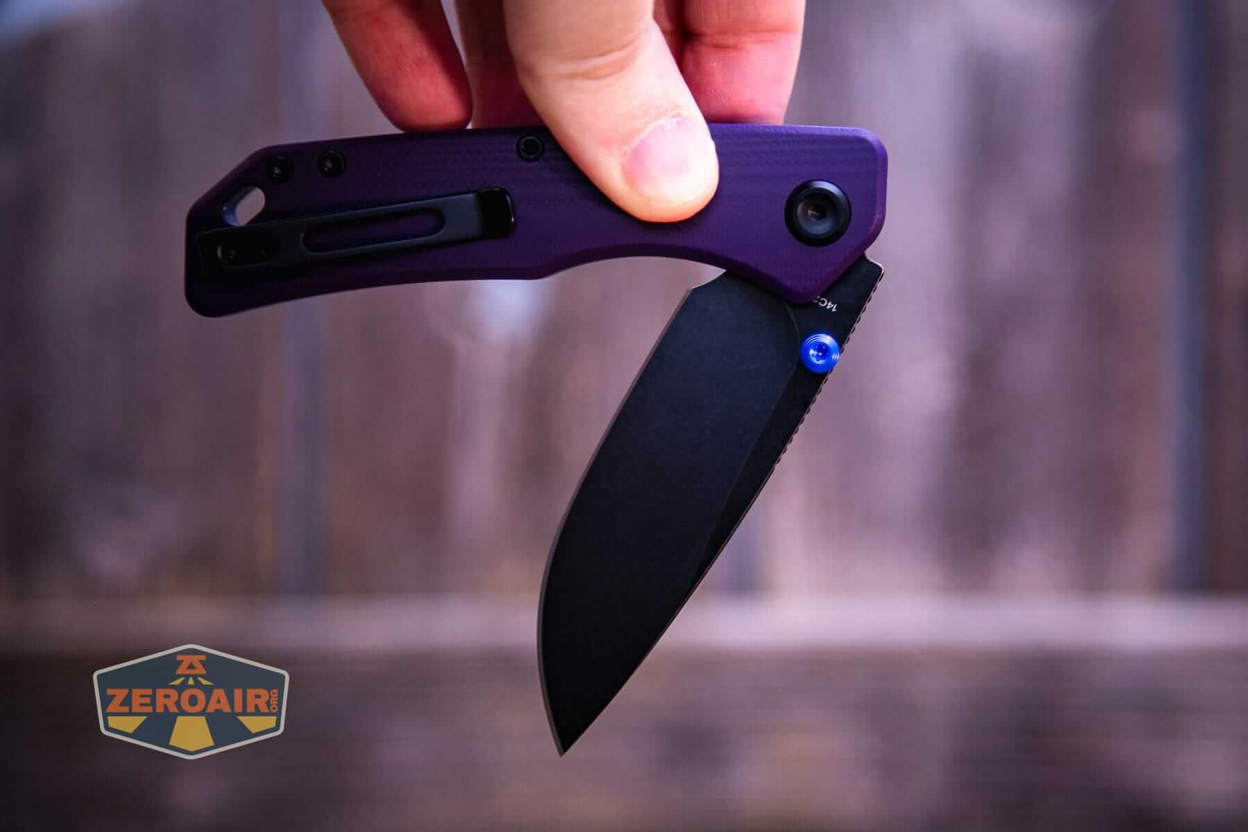 Vosteed Marten 330 Purple knife open in hand, button being pressed and swing shut