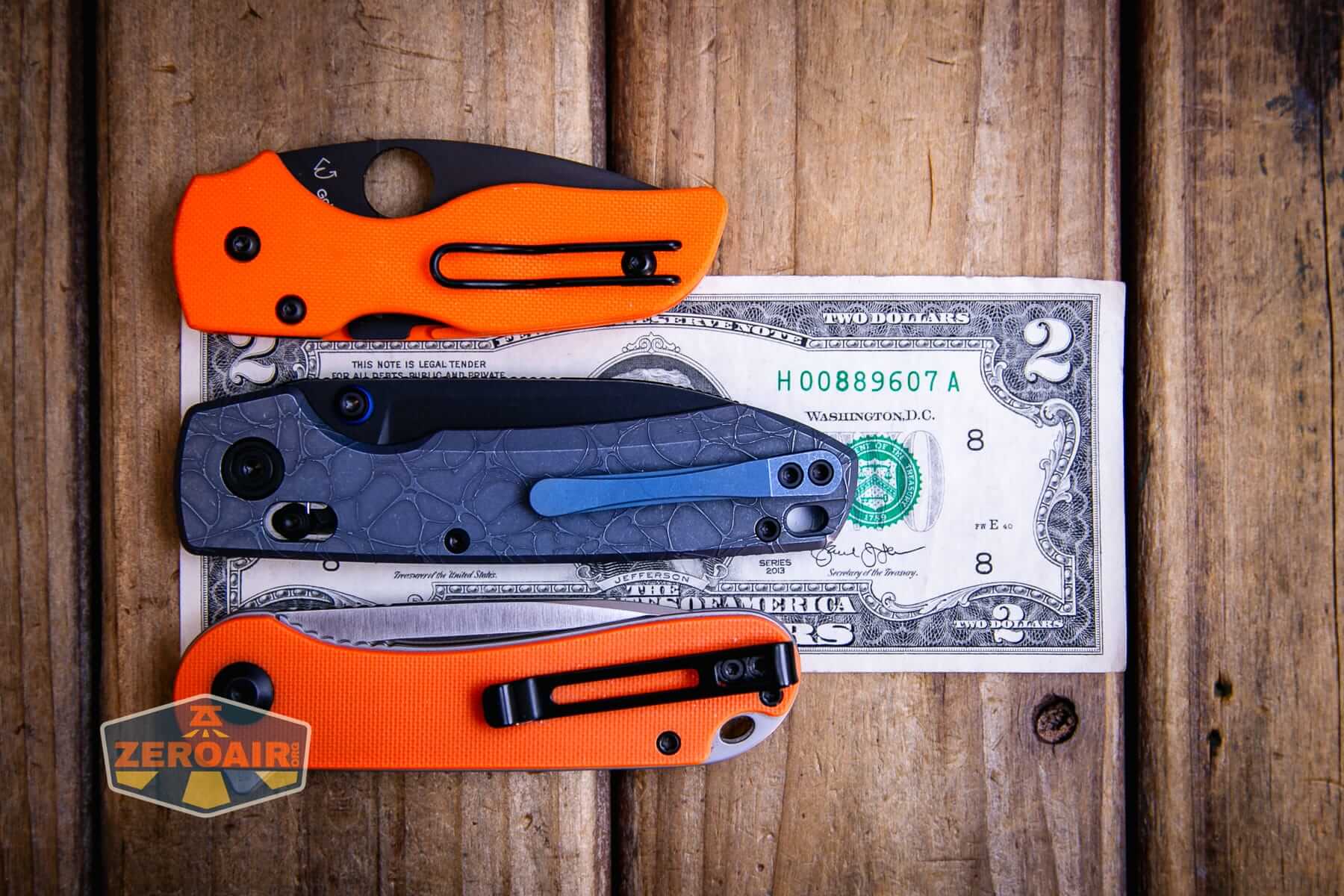 Vosteed Raccoon TiSlim knife on two dollar bill with comparable size knives